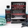 A complete car care kit, including a large black and red labeled box of Craig’s Waterless Wash & Wax Alternative for Drought, a blue microfiber towel, a green microfiber towel, a white spray nozzle, and a bottle of Craig's concentrated refill solution with a matching label—a perfect wax alternative ideal for drought conditions.