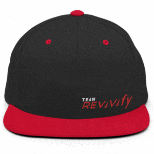 A Snap Back Cap featuring a sleek black crown with the text "TEAM REVivify" embroidered on the front, and accents including a red brim, top button, and eyelets.