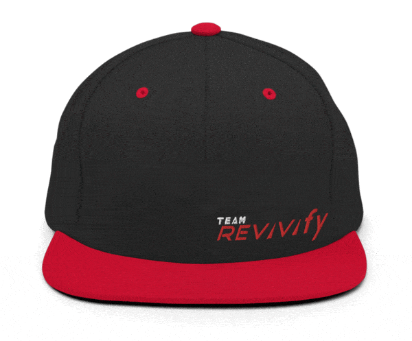 A Snap Back Cap featuring a sleek black crown with the text "TEAM REVivify" embroidered on the front, and accents including a red brim, top button, and eyelets.