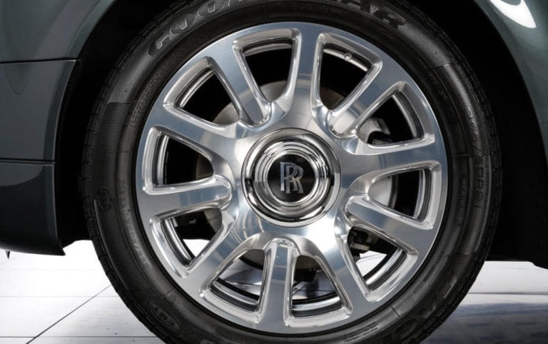 Close-up of a chrome wheel with multiple spokes on a Rolls-Royce car. The center cap features the Rolls-Royce logo.