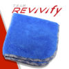 A blue microfiber towel is neatly folded with a partial view of its patterned backing. The background features a white and red design with the text "TEAM REVIVIFY" in grey and red letters.