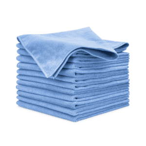 A neatly stacked pile of light blue microfiber cleaning cloths, with one cloth draped on top. The stack is set against a white background.